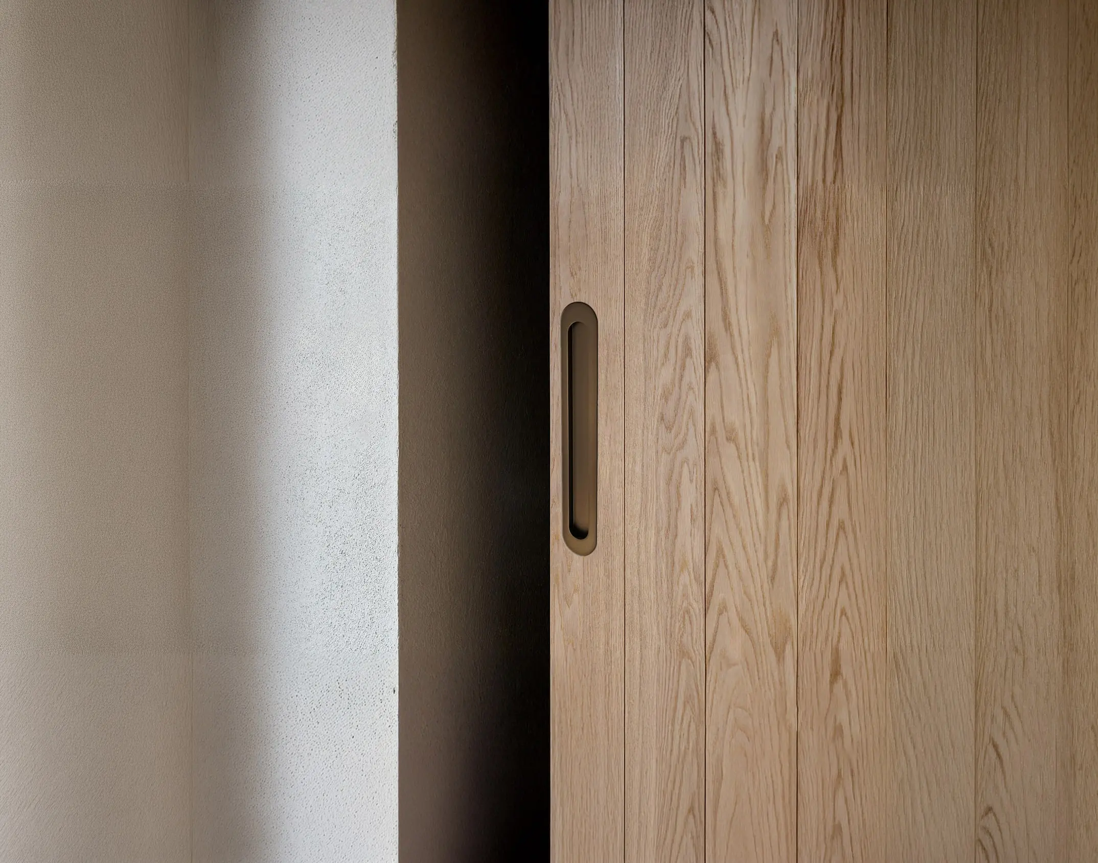 Zanda Duke flush pull on an oak sliding door, Ember Bronze