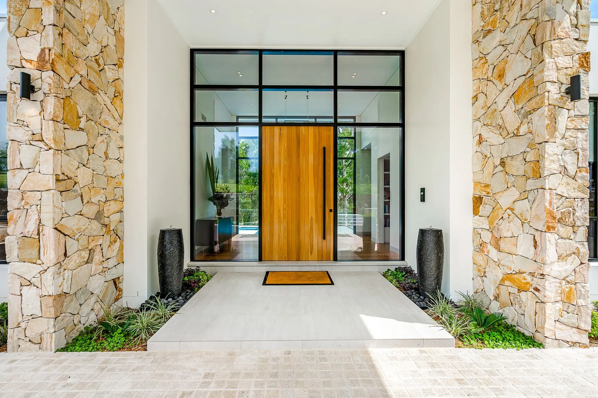 Zanda Polo 1800mm pull handle in Matt Black on a timber pivot entrance door