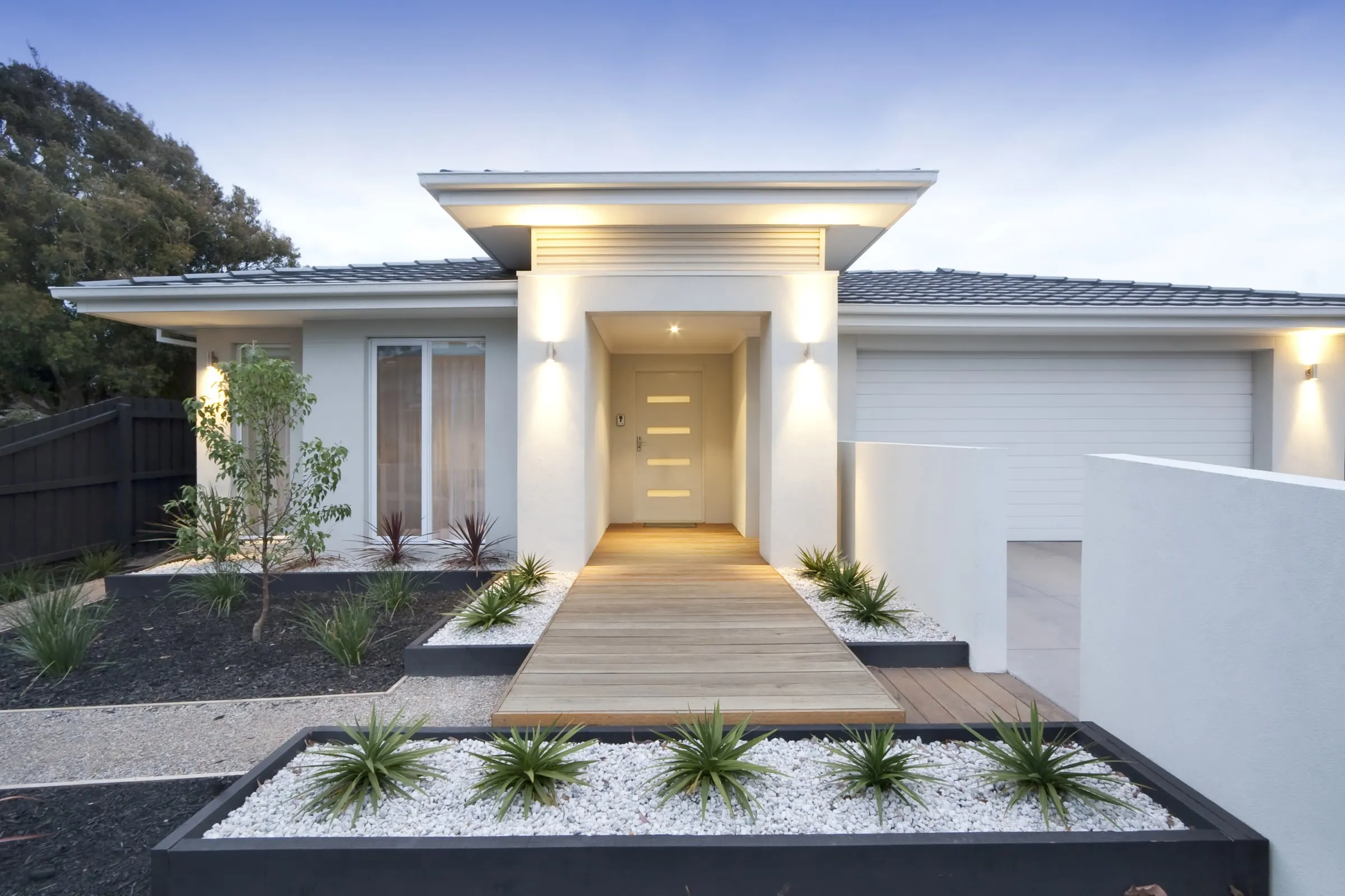 Modern Australian home at dusk with a Hume BAL40 entrance door, the kind of whole-of-house supply Integrity prices