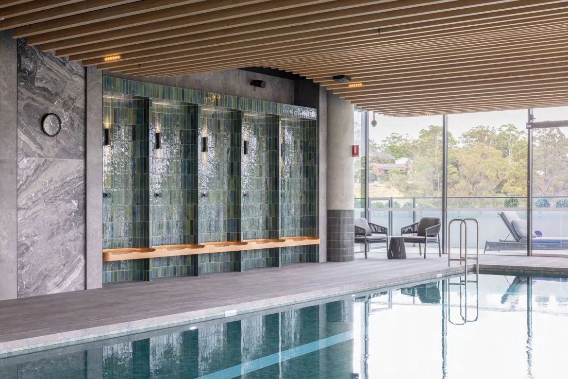 Timber-look aluminium clip-on battens forming a ceiling above an indoor pool