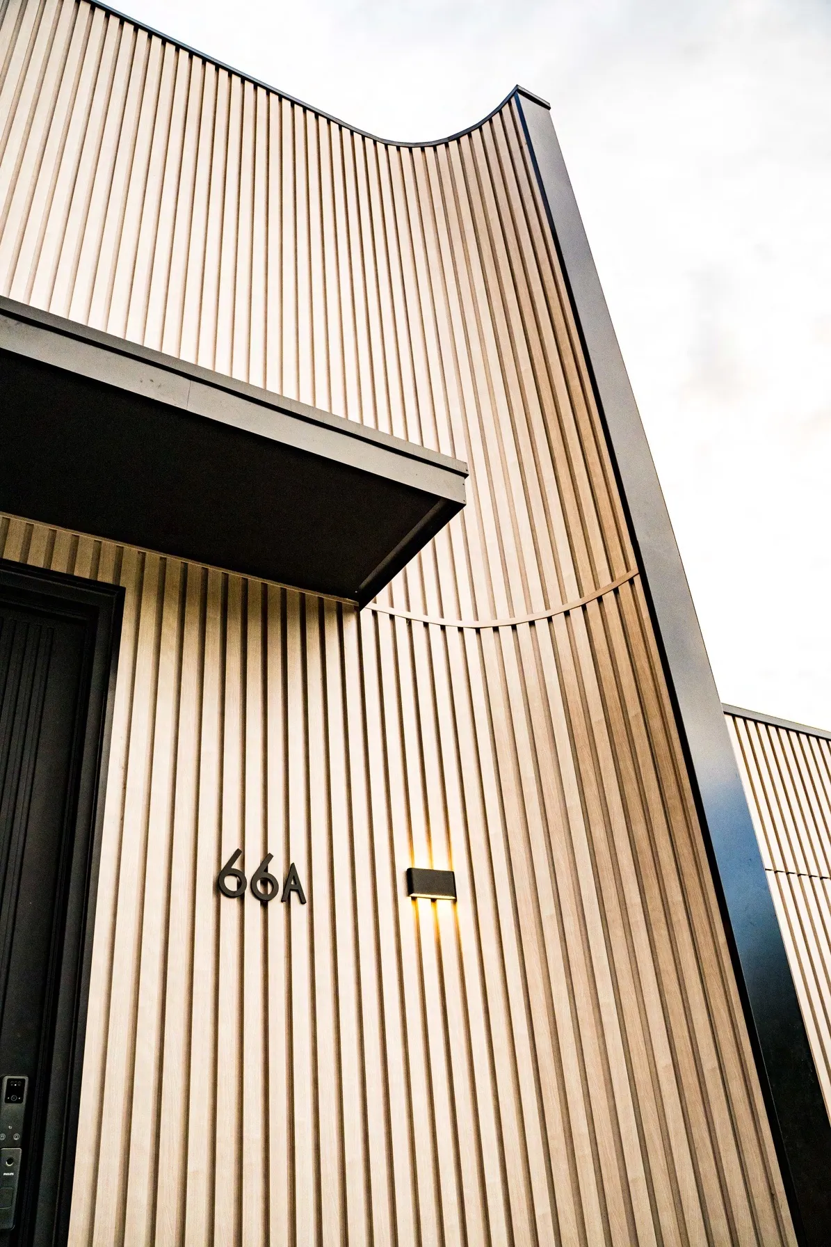 Curved castellated timber-look aluminium cladding on a residential facade